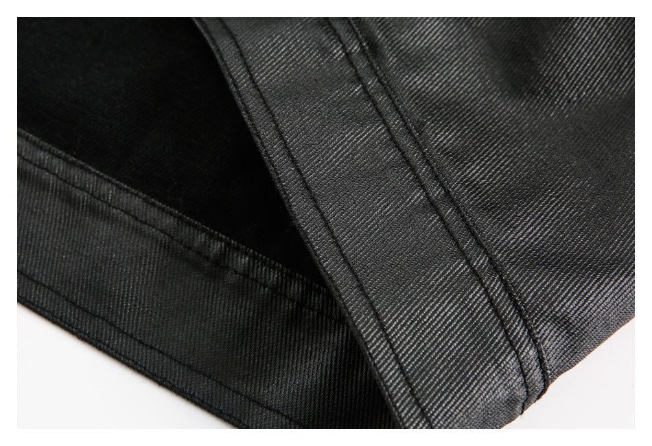 Close-up of black garment fabric with a wide stitched seam and folded edge.