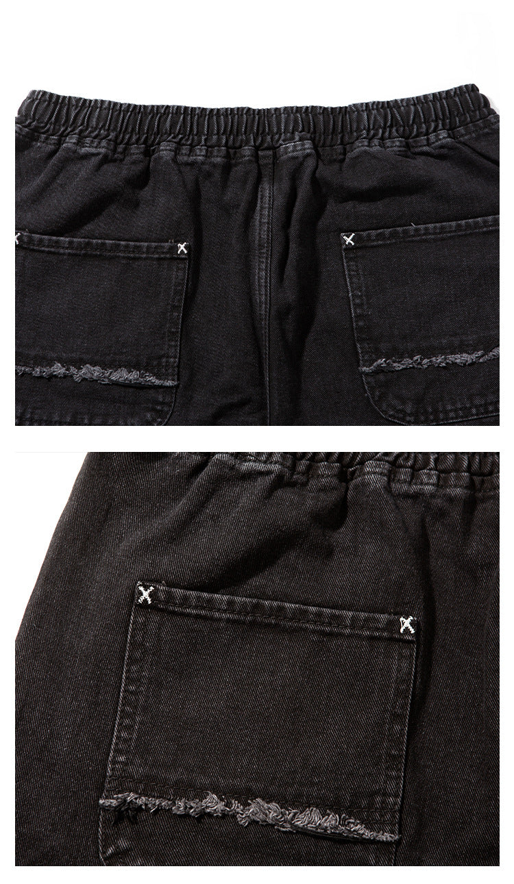 Rear view of black denim joggers with an elastic waistband and two patch pockets with frayed lower edges.