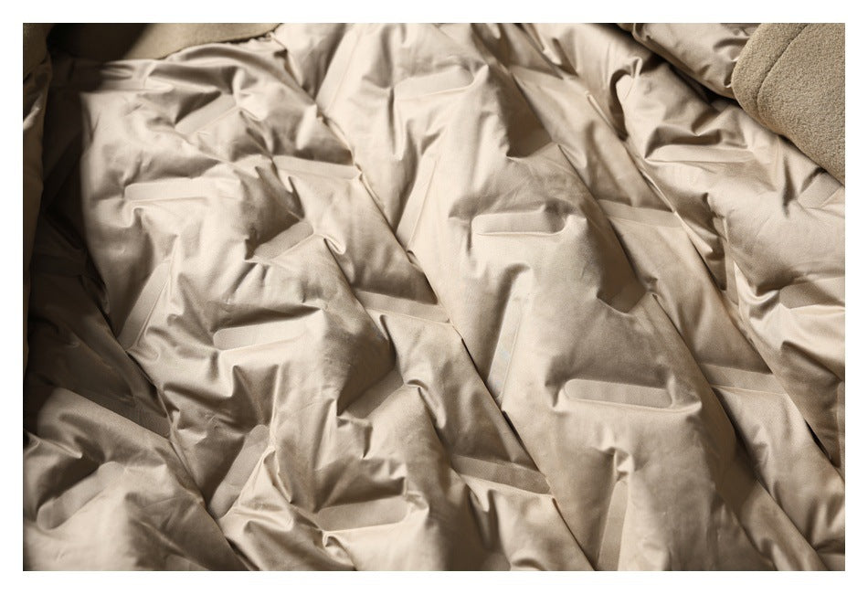 Close-up of a beige coat laid in folds, showing several horizontal pocket openings.