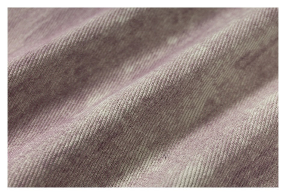 Extreme close-up showing the mauve garment's mottled surface and diagonal weave texture.
