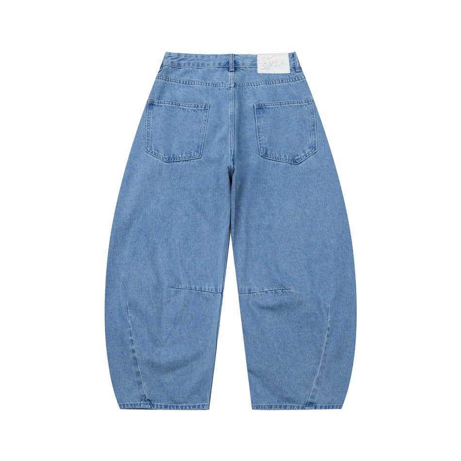 Back view of light blue barrel-leg denim jeans with two patch pockets and a white waistband label