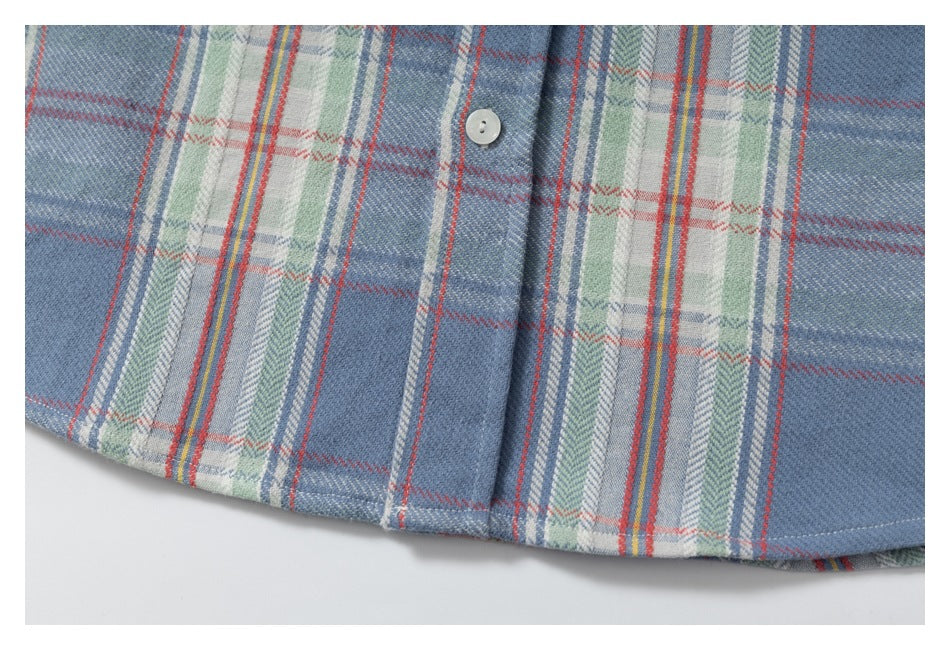 Close-up of the curved hem and plaid pattern of a blue shirt.
