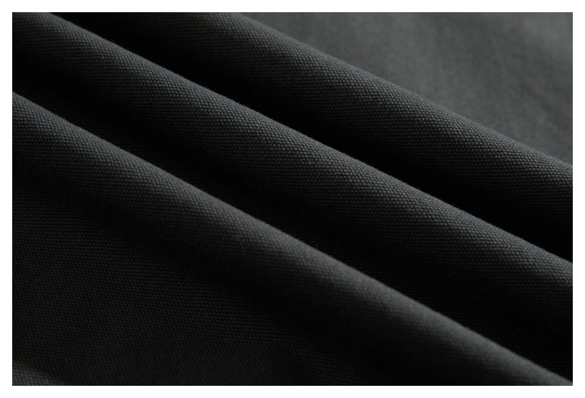 Close-up of textured charcoal fabric arranged in soft folds.