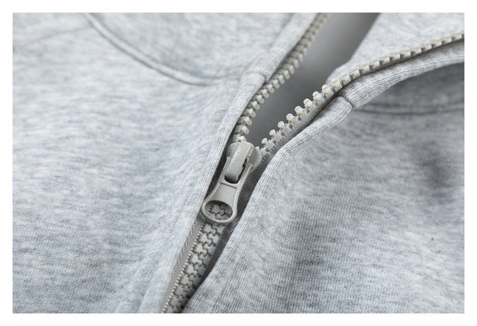 Close-up of the light gray zipper and heathered fabric on a gray hoodie.