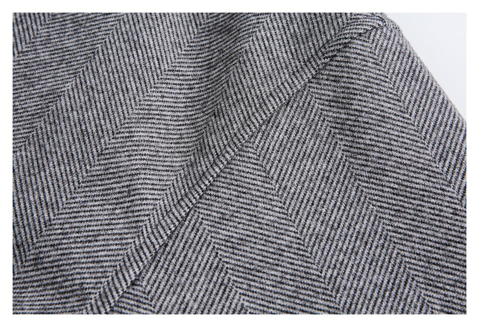 Close-up of gray and black herringbone-patterned garment fabric.