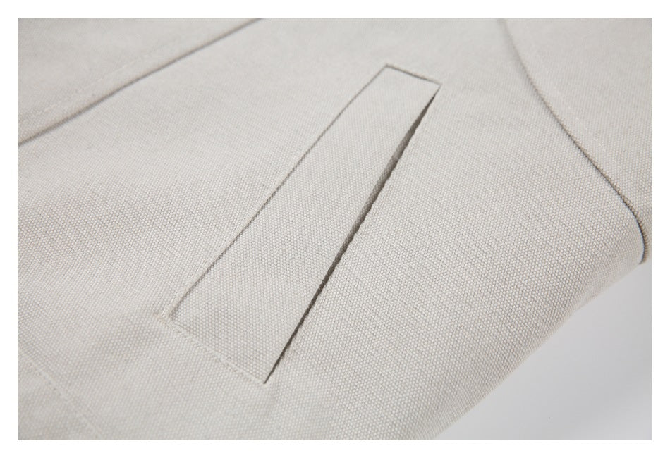 Close-up of a beige jacket’s narrow welt pocket opening and stitched seams.