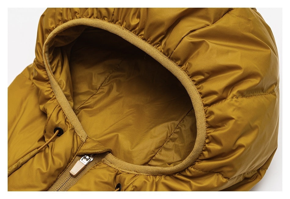 Close-up of the mustard-gold jacket hood opening, with tan edging, a drawcord, and part of the front zipper.