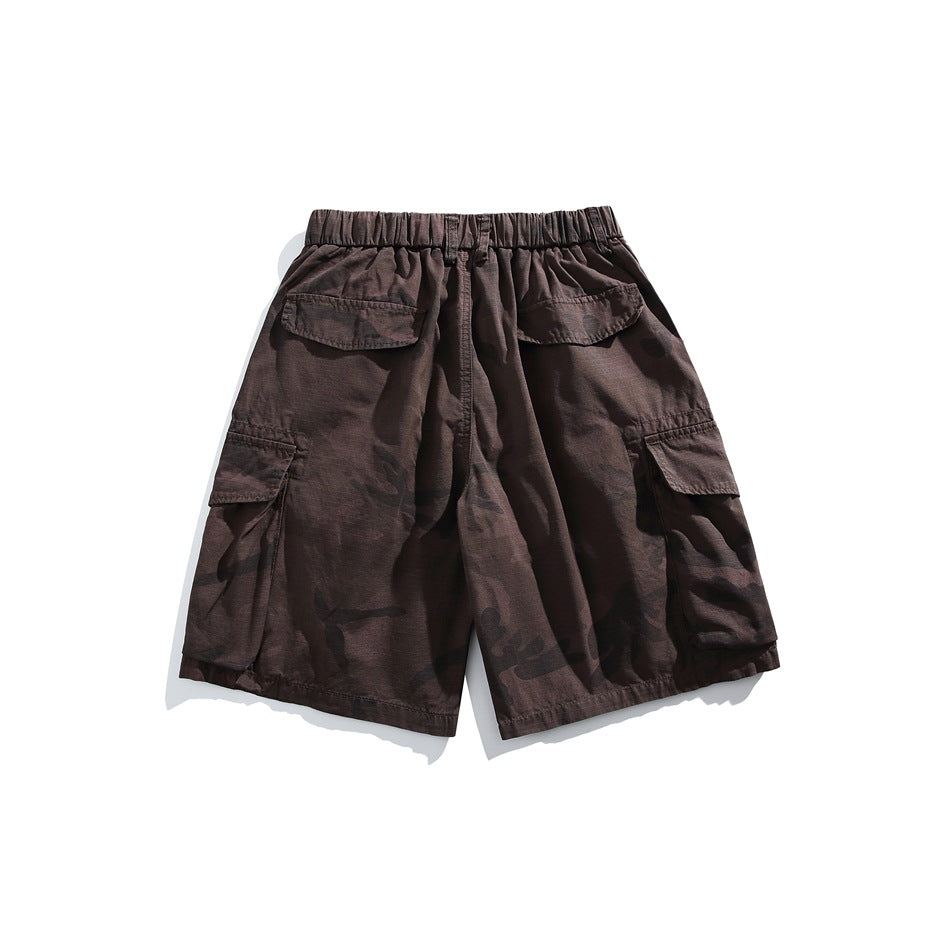 Back view of dark brown camouflage cargo shorts with an elastic waist, rear flap pockets, and side cargo pockets.
