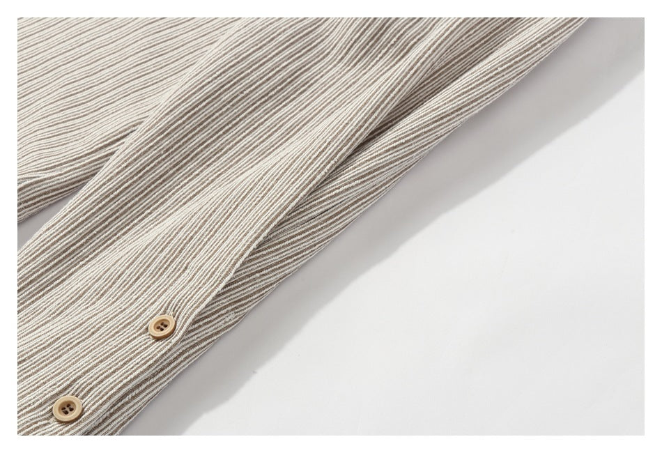 Close-up of a striped garment placket with two tan buttons.