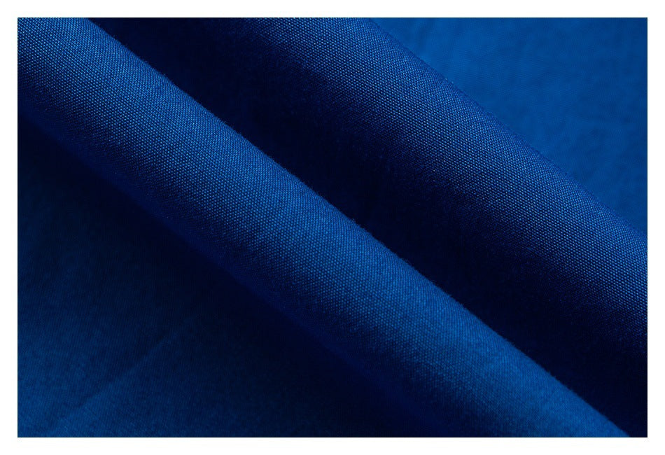 Macro view of deep blue fabric folds showing its fine woven texture.