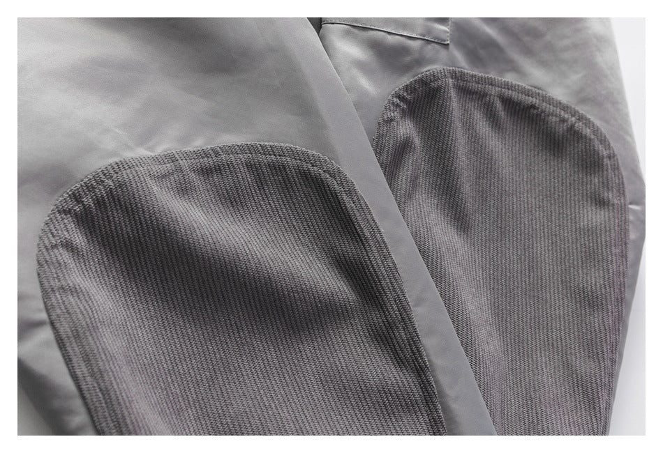 Close-up of two gray knit-lined pockets on a smooth gray garment.