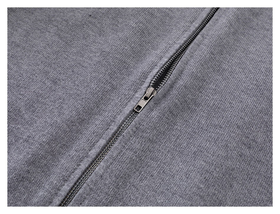 Close-up of the metal zipper and gray knit fabric on the cardigan.