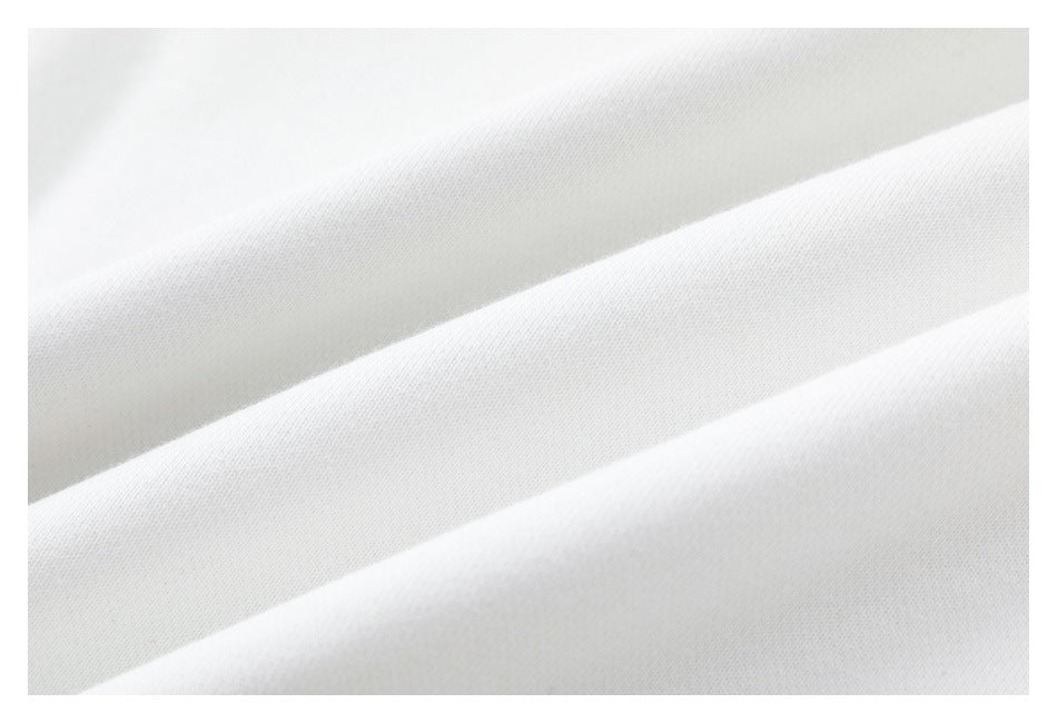 Macro view of the smooth white sweatshirt fabric in soft diagonal folds.