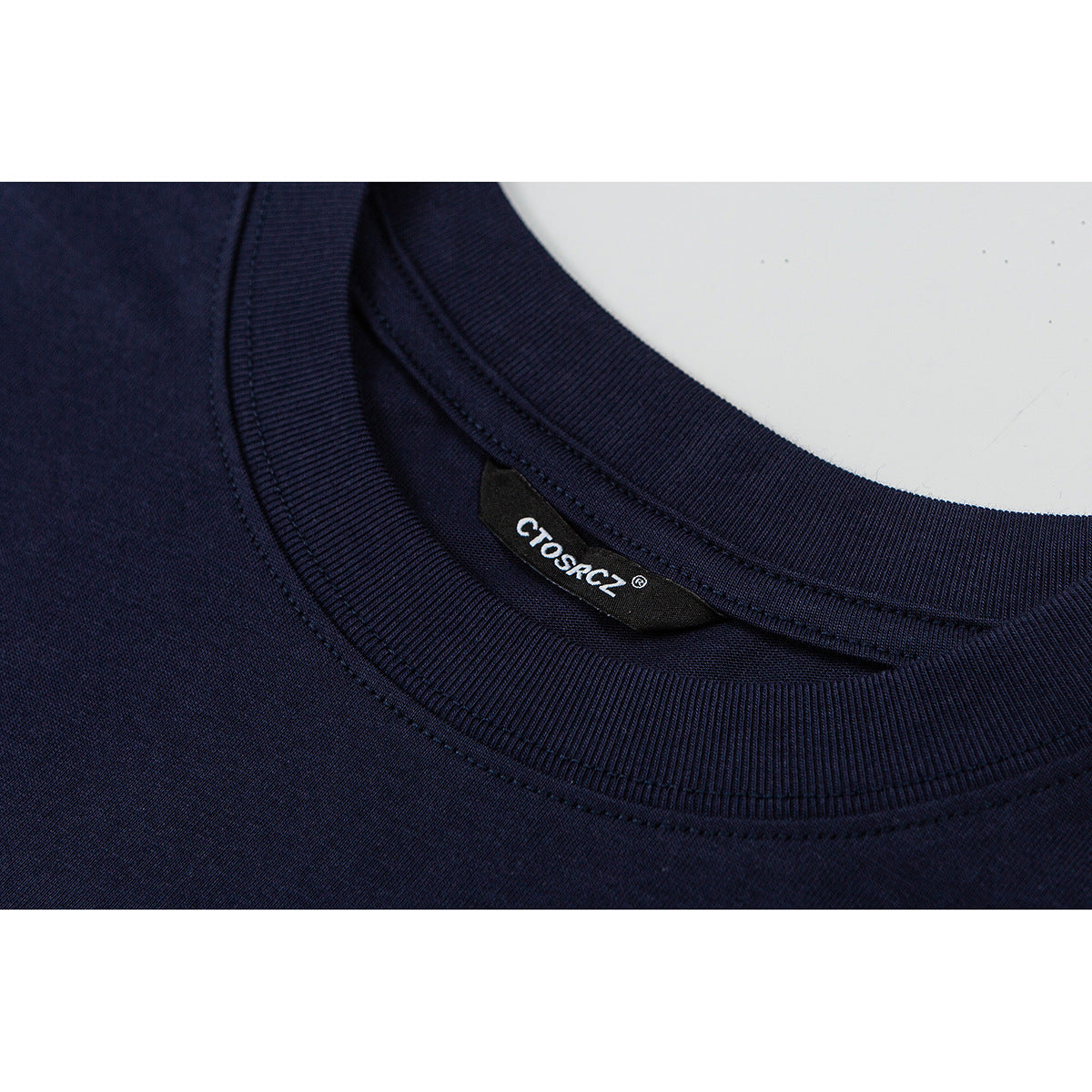 Close-up of a navy T-shirt's ribbed crew neck and sewn-in brand label.