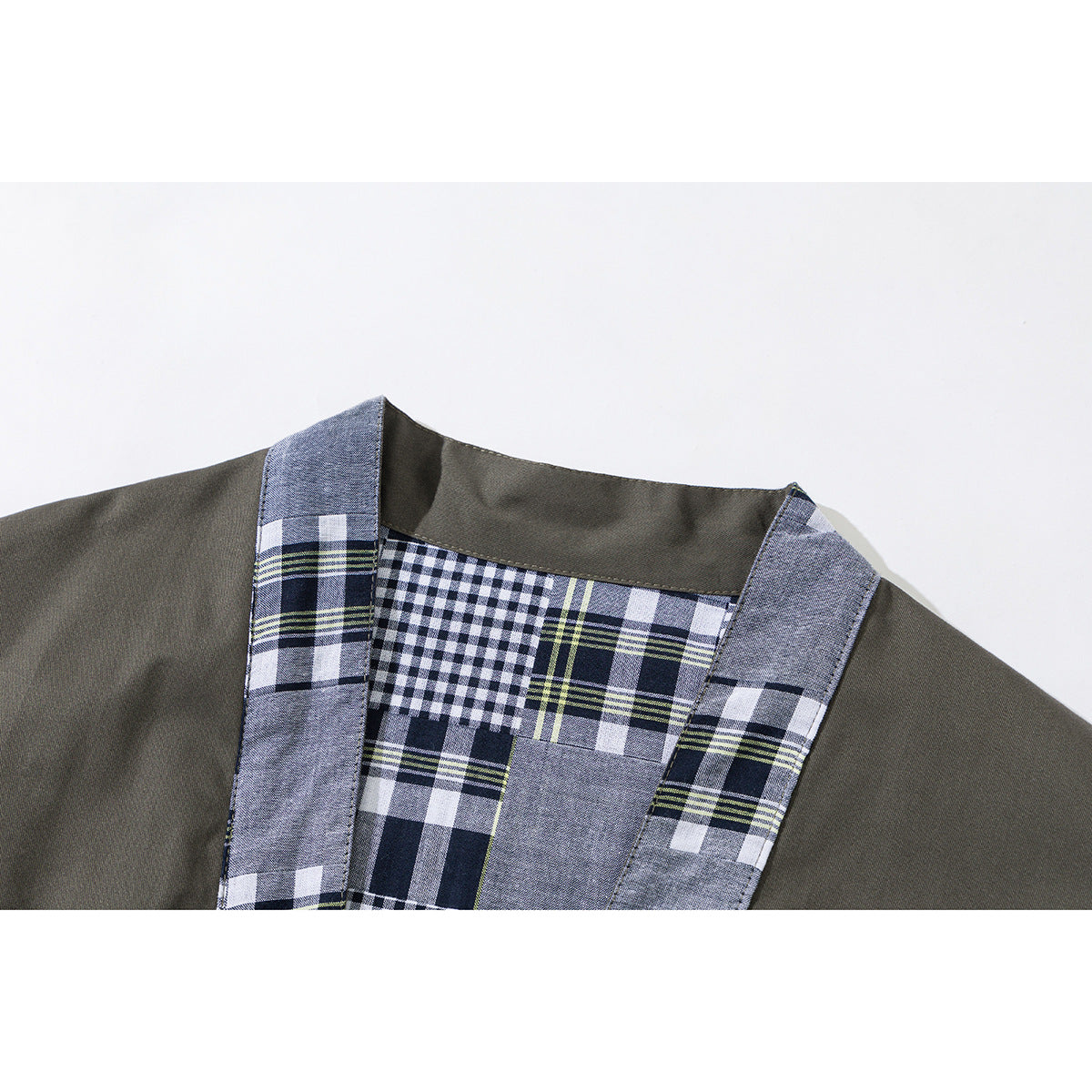 Close-up of an olive jacket neckline with blue-gray, navy, white, and lime plaid trim and lining.