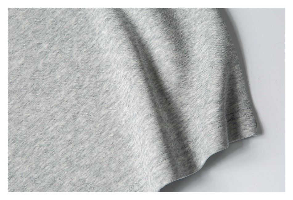 Close-up of the light gray heather garment's side and lower edge.