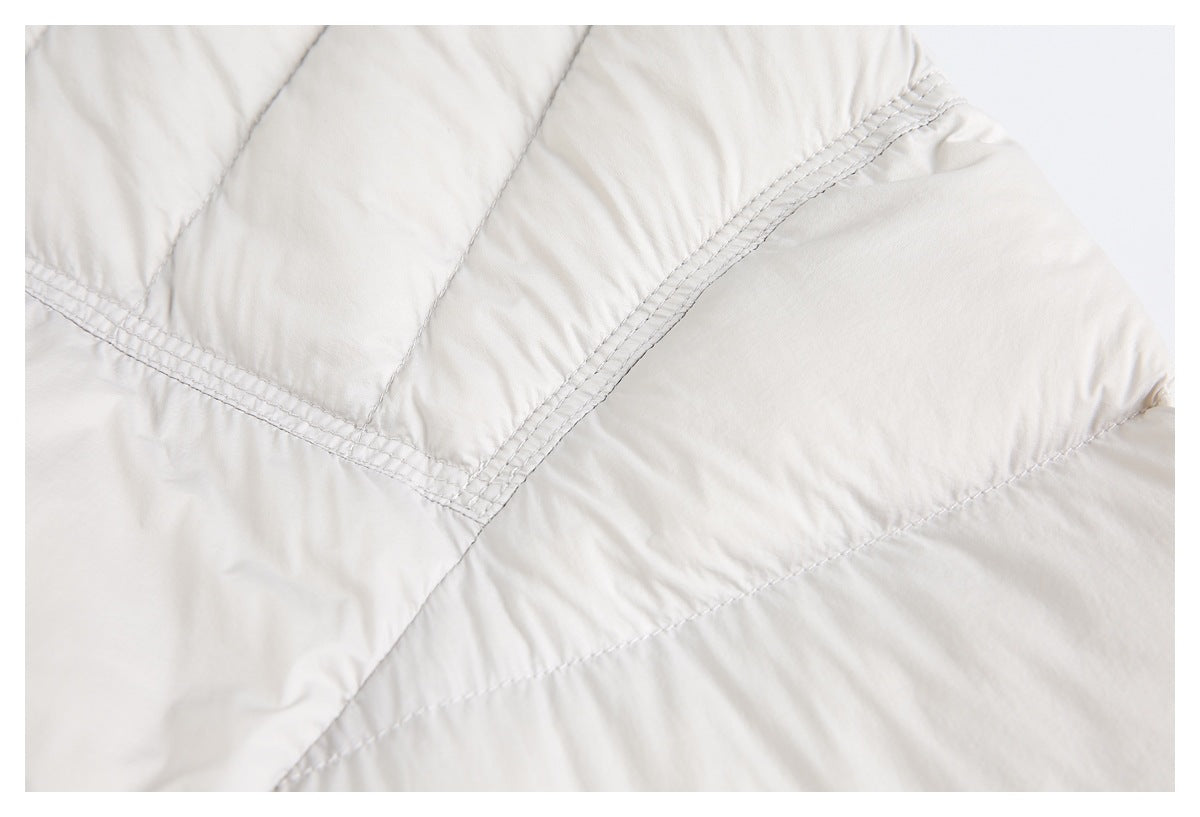 Close-up of the off-white puffer jacket's quilted panels and multiple rows of stitching.