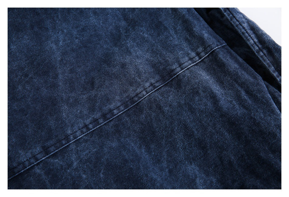 Close-up of dark blue fabric with a diagonal seam and folded edge.