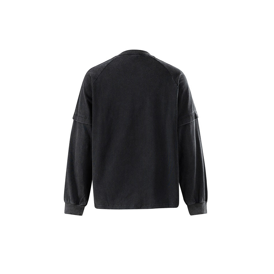 Back view of washed black long-sleeve top showing raglan seams, layered sleeve detail and ribbed cuffs