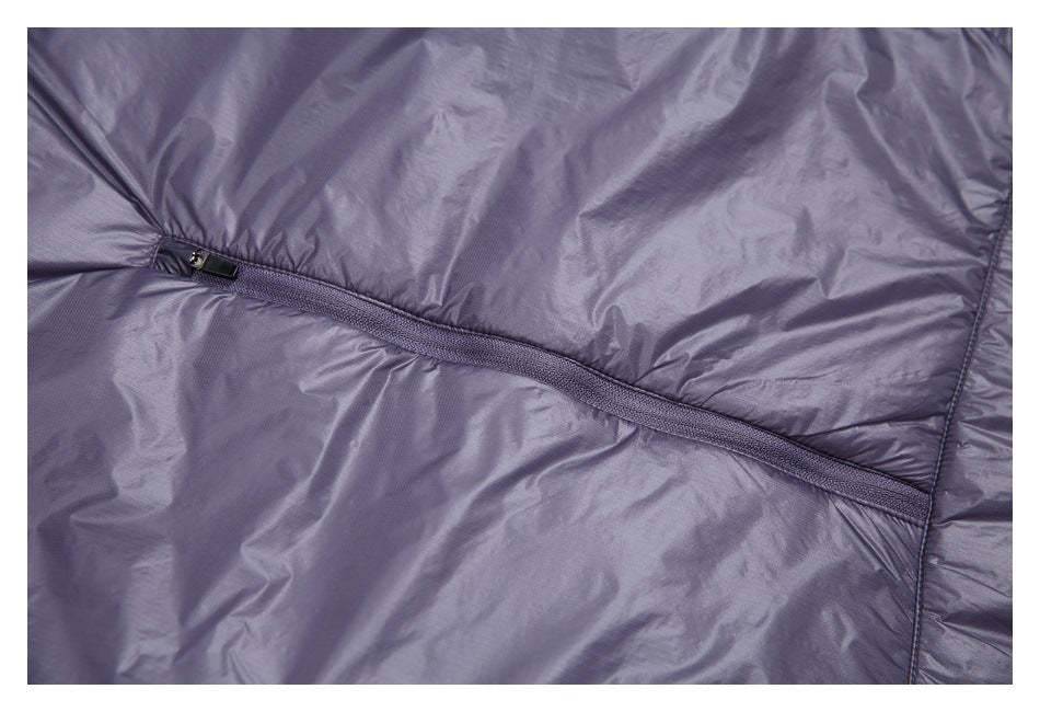 Close-up of a dark purple jacket with a long zipper running across the padded panels.