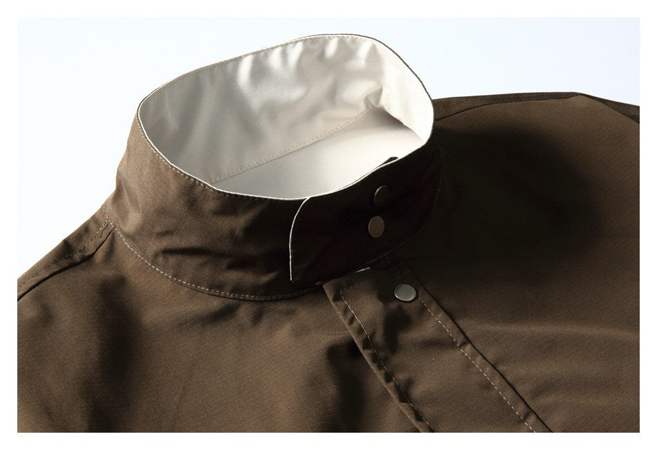 Close-up of a dark brown jacket collar, showing its light inner lining and snap-button closure.
