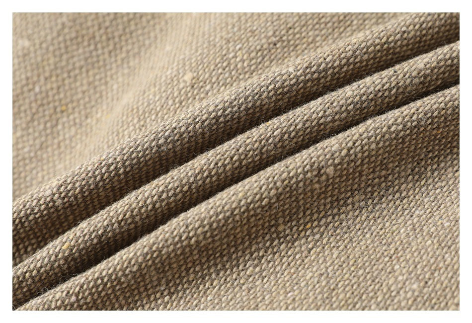 Macro close-up of the beige and brown woven jacket fabric, showing its textured weave and folded edge.