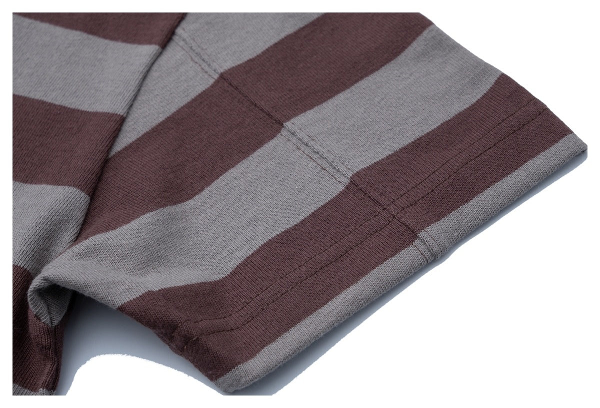 Close-up of a gray and dark brown striped knit garment hem with visible stitching.