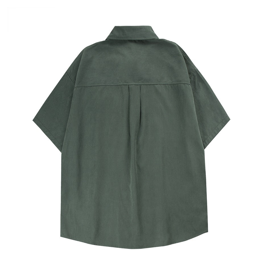 Back view of a dark green oversized short-sleeve collared shirt with a center pleat.