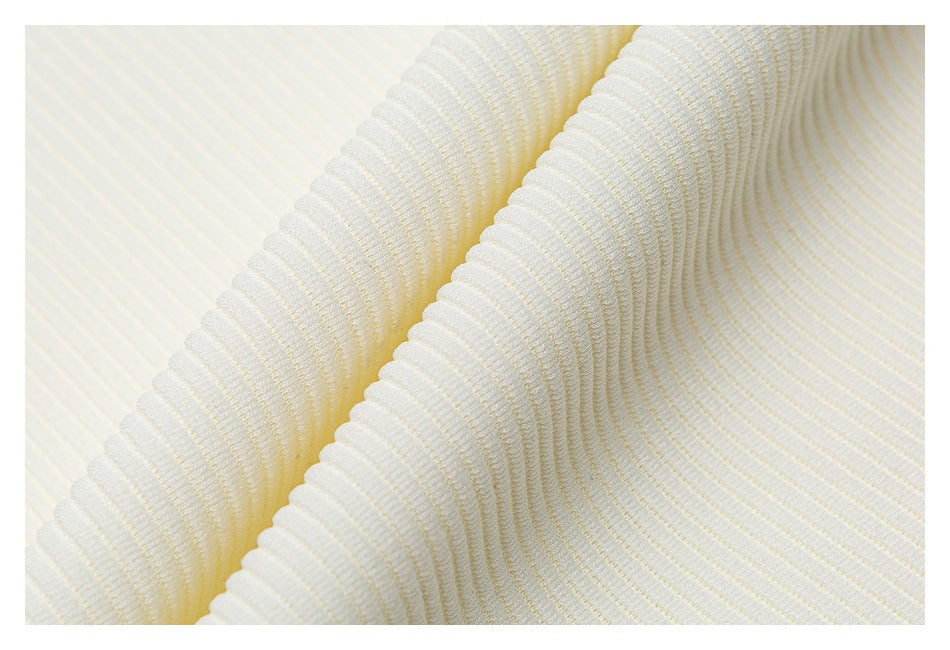 Extreme close-up of the ivory top's ribbed fabric, folded to show its texture.