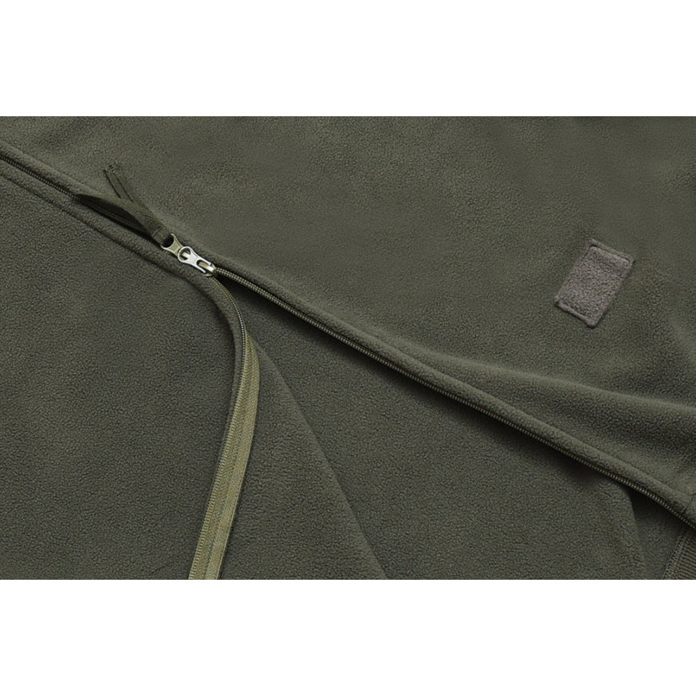Close-up of an olive-gray jacket's zipper and a small blank rectangular patch.