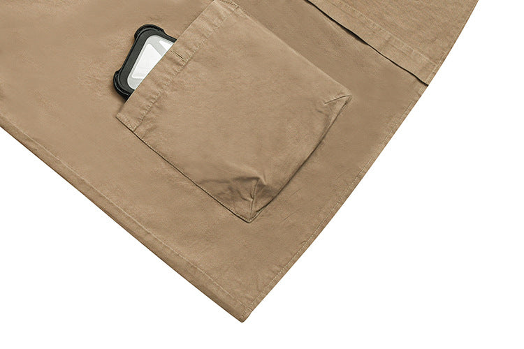 Close-up of a tan shirt pocket holding a smartphone, with the pocket opening visible.