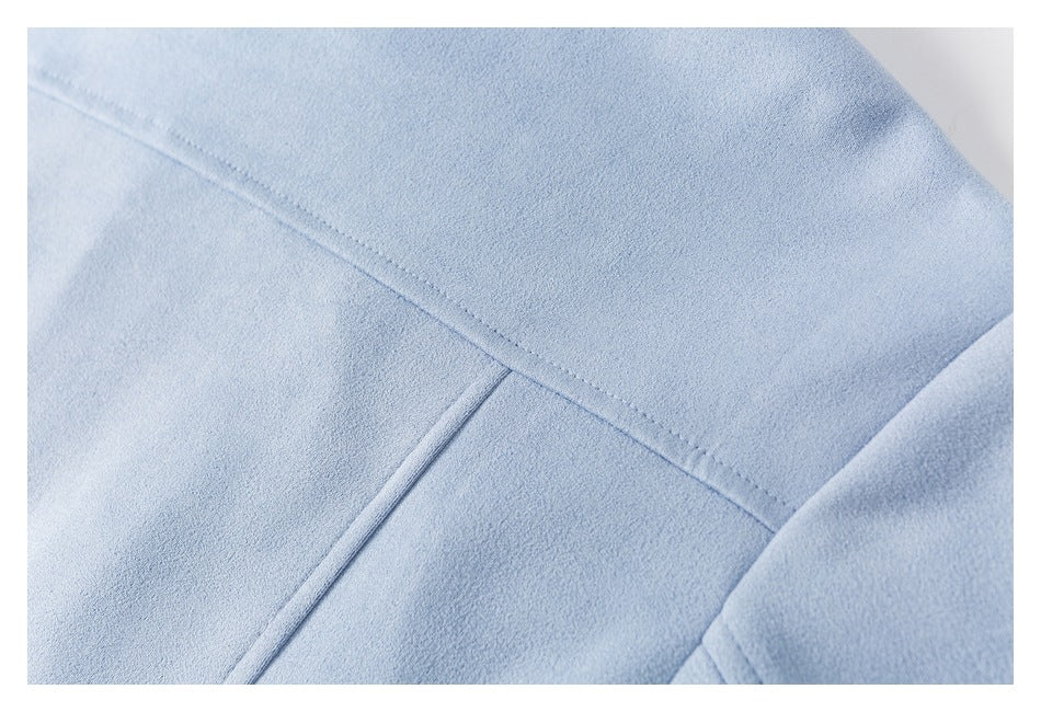 Close-up of light blue jacket fabric with intersecting stitched seams and a panel edge.