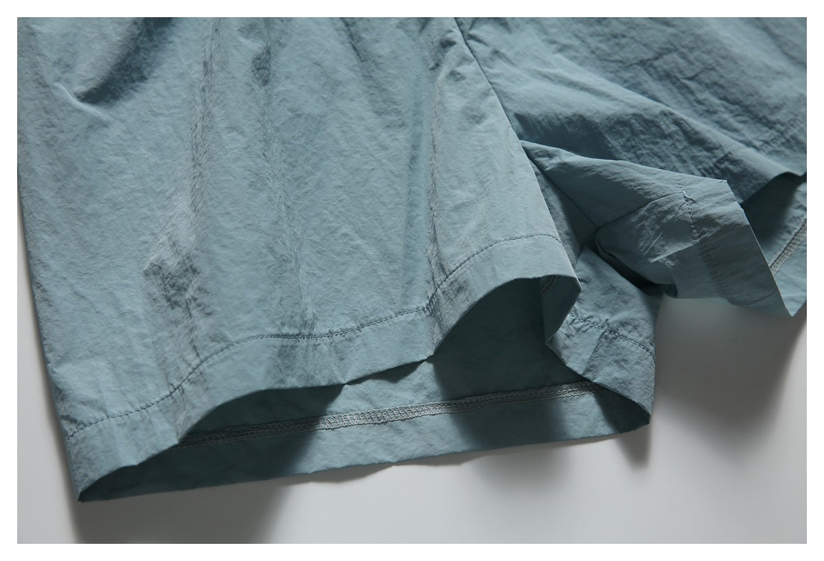 Close-up of the blue-gray garment’s leg hems and visible interior seam stitching.