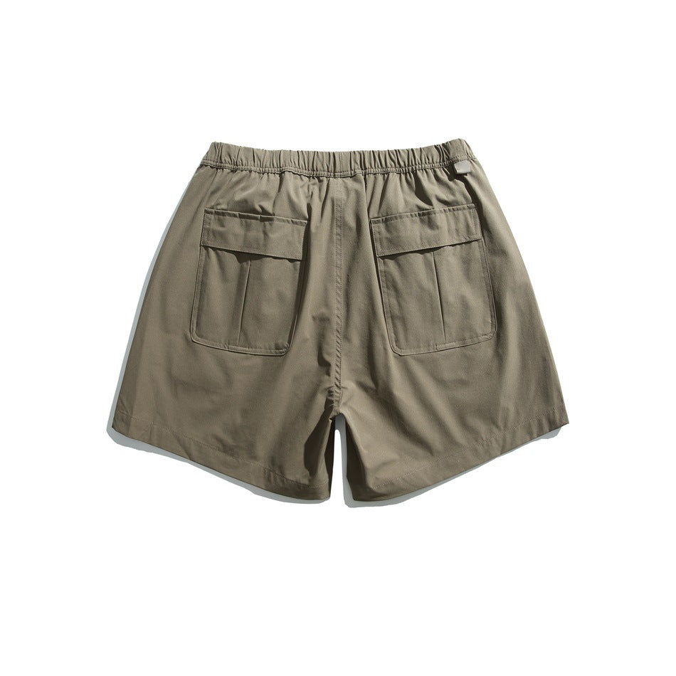 Back of olive shorts with an elastic waist and two large flap pockets.