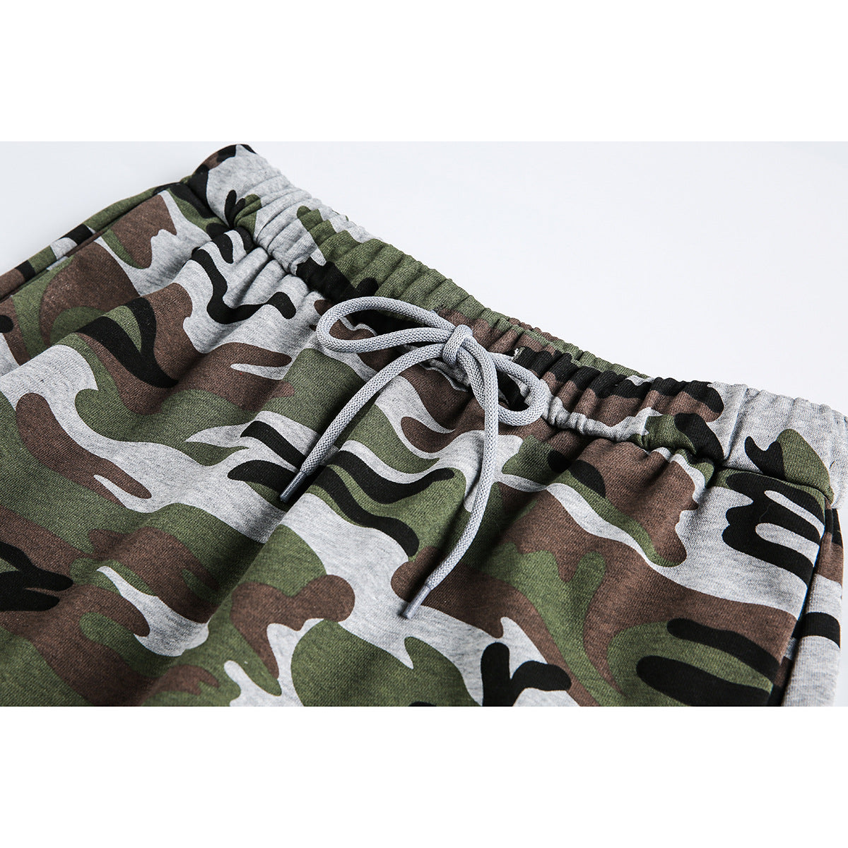 Close-up of a green, brown, black, and gray camouflage skirt waistband with a gray drawstring.