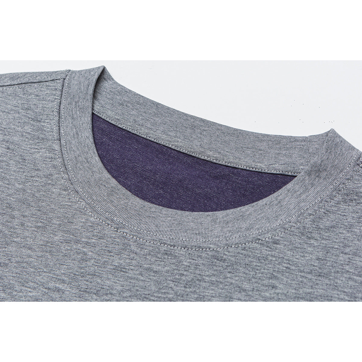 Close-up of a heather gray T-shirt neckline with ribbed collar and dark purple inner neck panel.