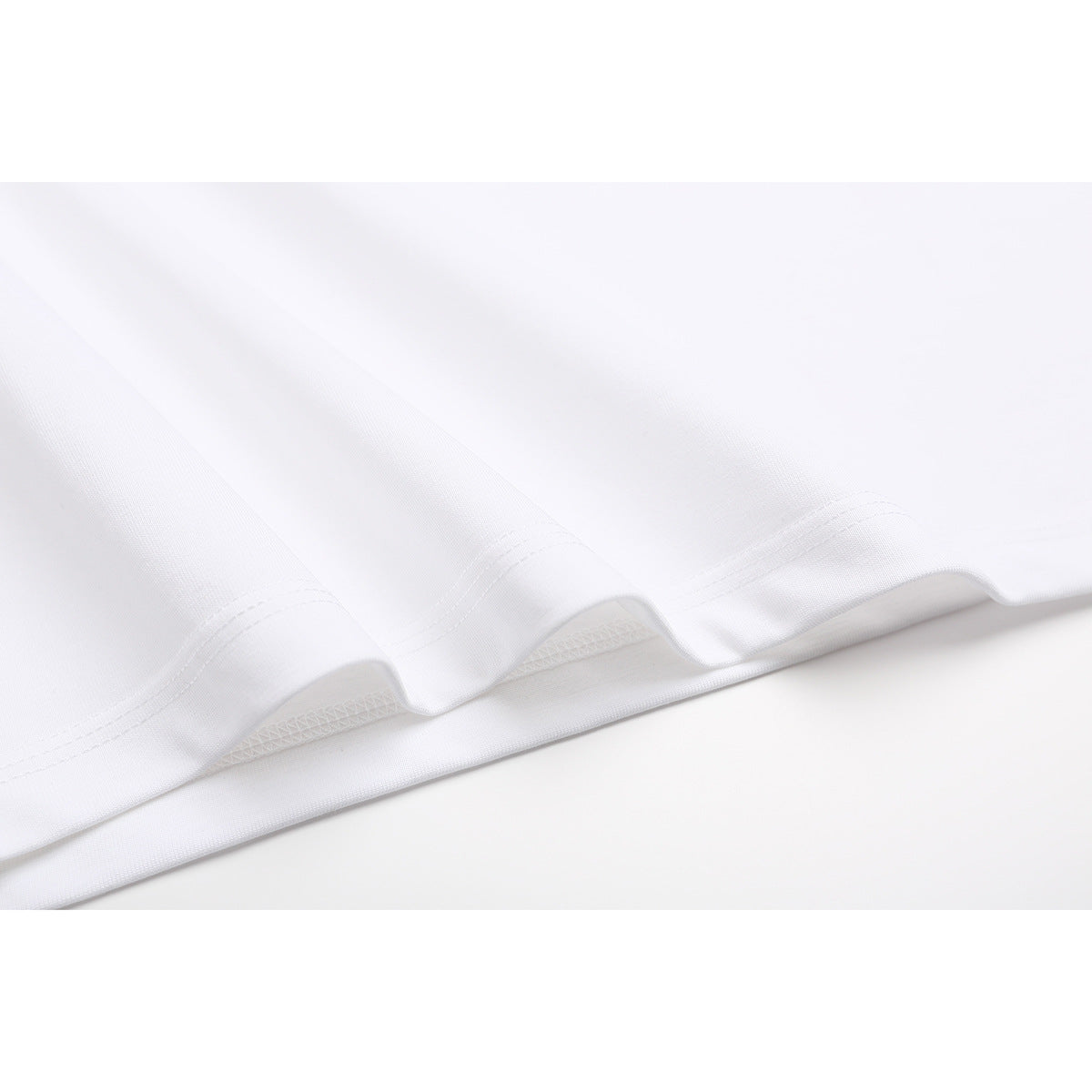 Close-up of the white T-shirt bottom edge showing the stitched hem.
