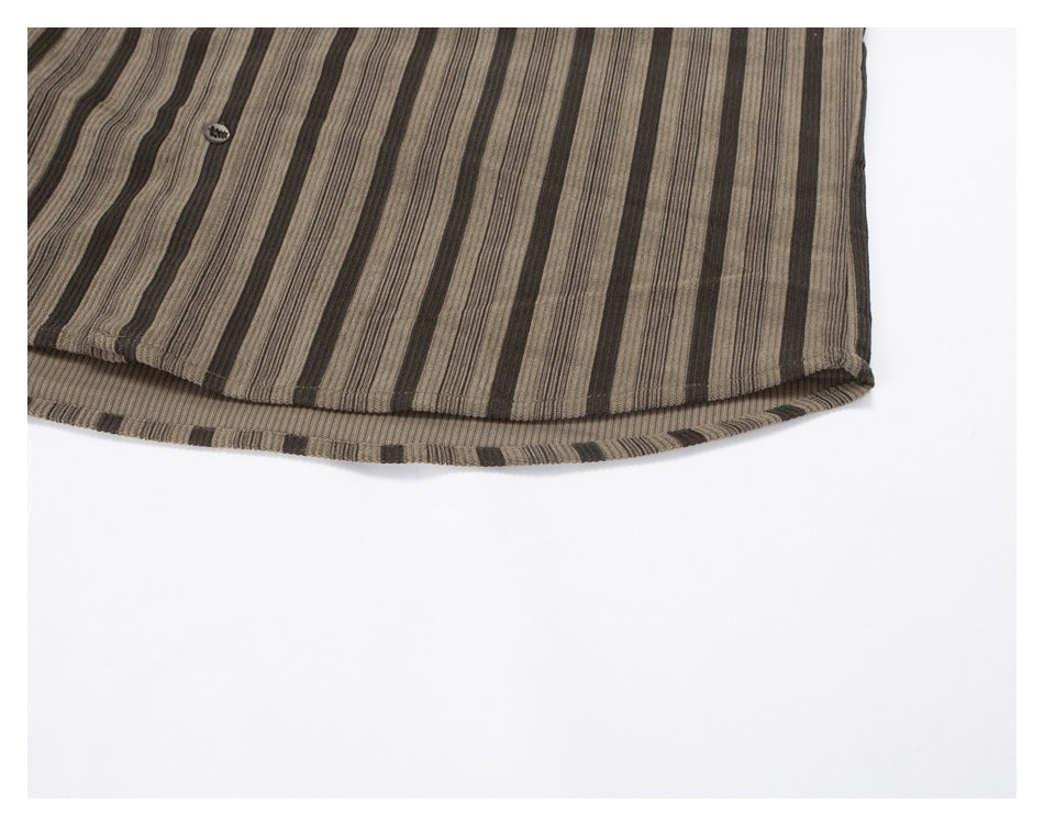 Close-up of a curved hem on taupe and dark brown striped garment fabric, with a small button near the edge.