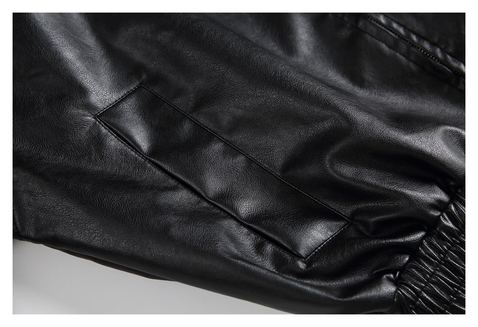 Close-up of a black jacket sleeve with a stitched rectangular panel and gathered cuff.