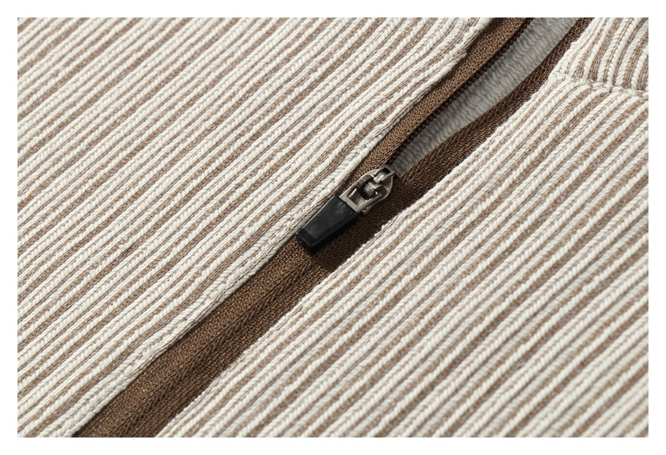 Close-up of a brown zipper and metal pull on cream and brown striped fabric.