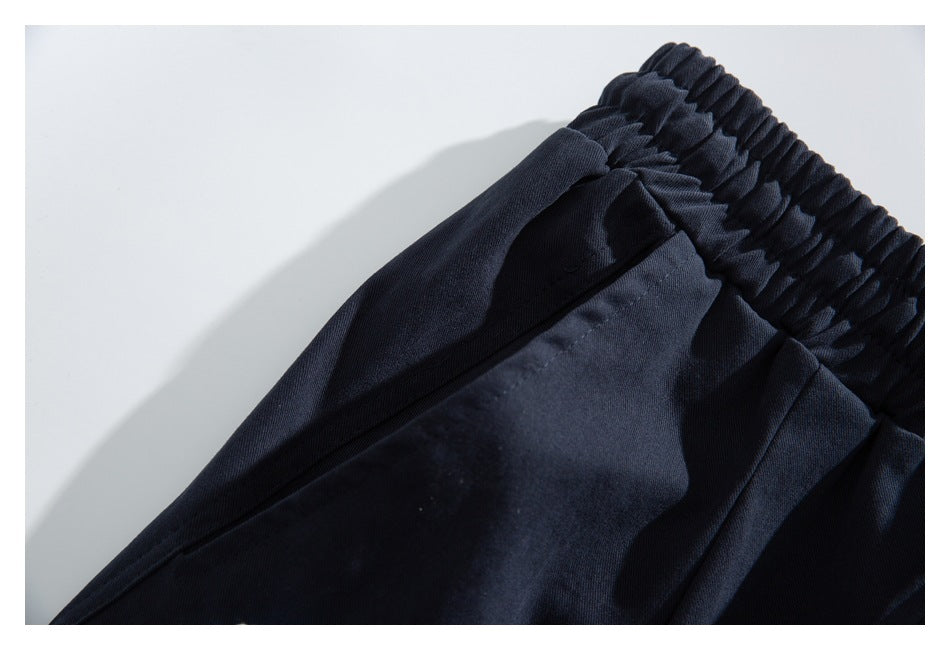 Close-up of dark navy bottoms showing a gathered elastic waistband and angled pocket seam.