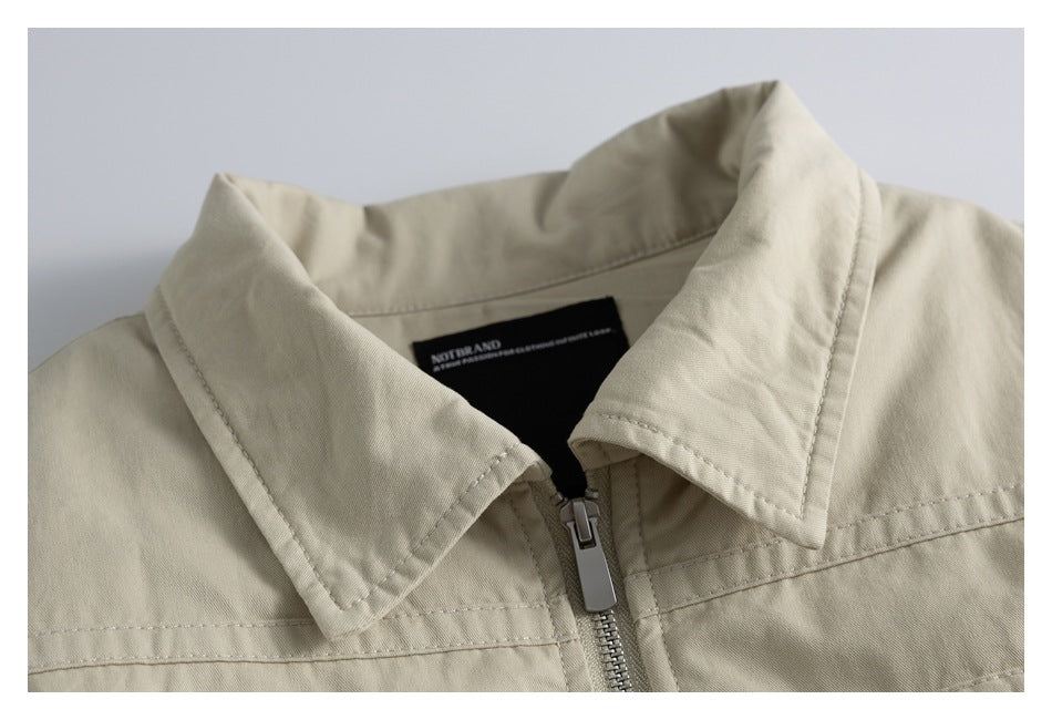 Close-up of a light beige jacket collar and front zipper, with the inner neck label visible.