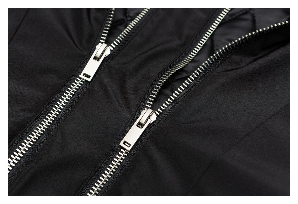 Close-up of a black garment with several silver metal zippers.