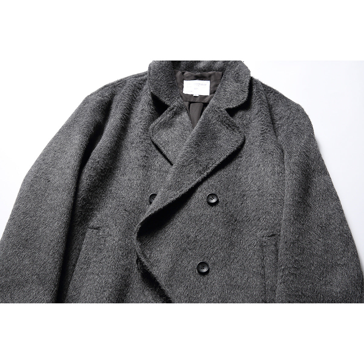 Close front view of a dark charcoal gray textured coat with wide lapels and black buttons.