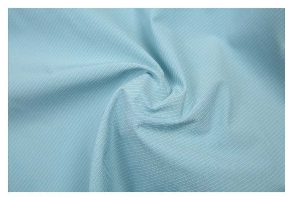 Close-up of pale blue fabric with fine, subtle stripes, draped into soft folds.