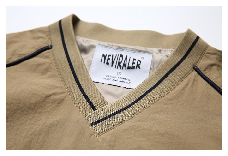 Close-up of a tan garment's V-neck collar with navy stripes and a visible neck label.