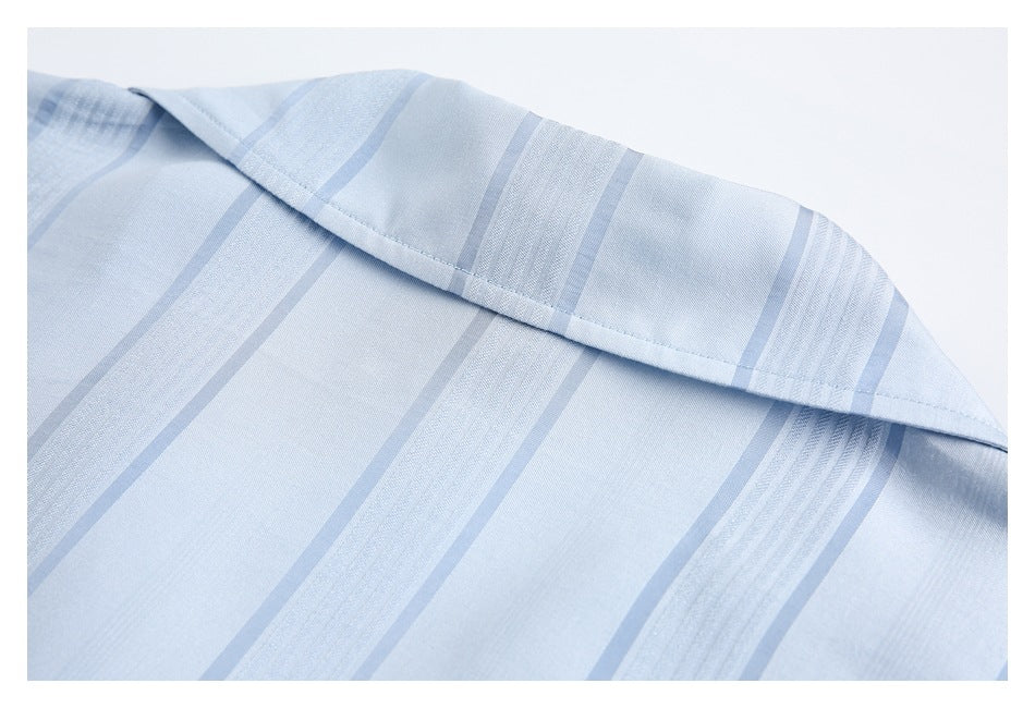 Close-up of a light blue striped shirt collar and stitching.