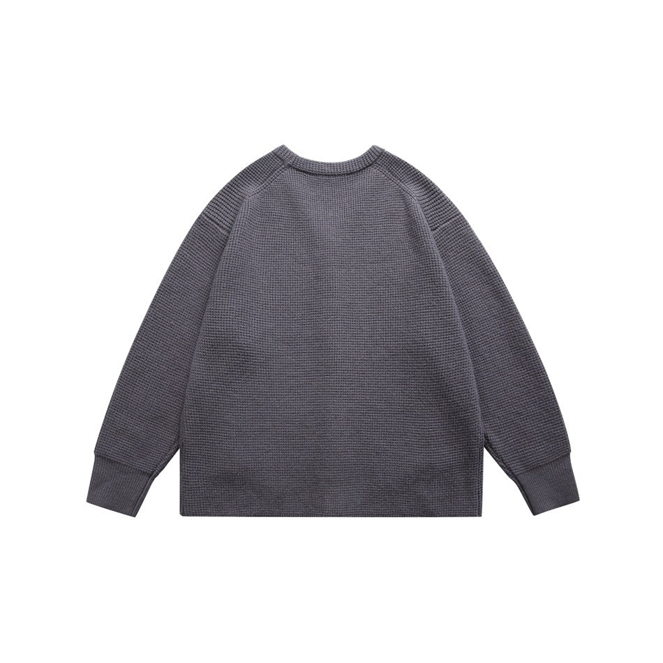 Back view of a charcoal gray knit cardigan with raglan sleeves and ribbed cuffs.