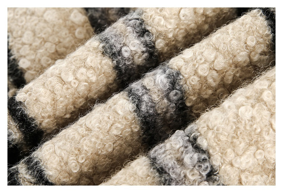 Macro view of the jacket's curly cream, gray, and black striped fabric texture.