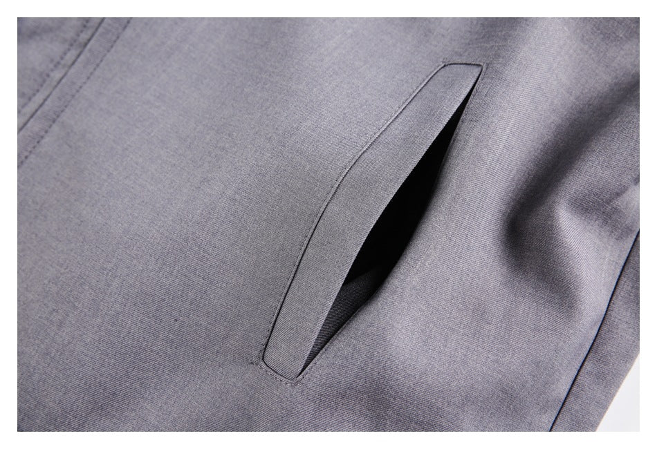 Close-up of a slanted welt pocket on a gray garment.